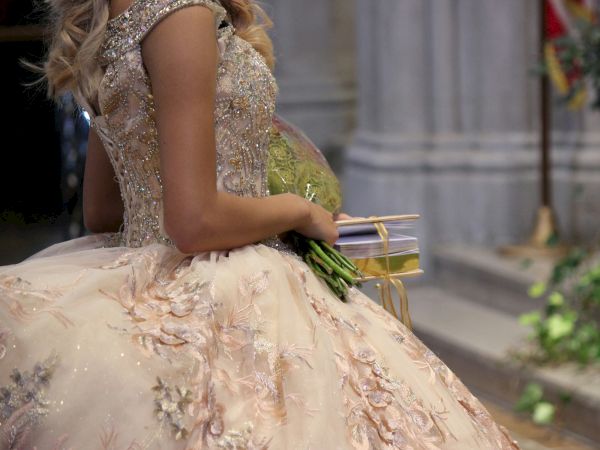 Quincea&ntilde;era in a ball gown holding a bouquet