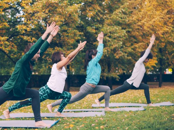 Group practicing yoga outdoors in a park
